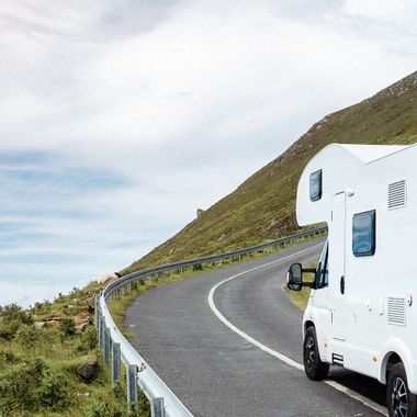 Una furgoneta camper sube una cuesta por una carretera.