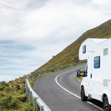 A motorhome drives along a road with a beautiful view.